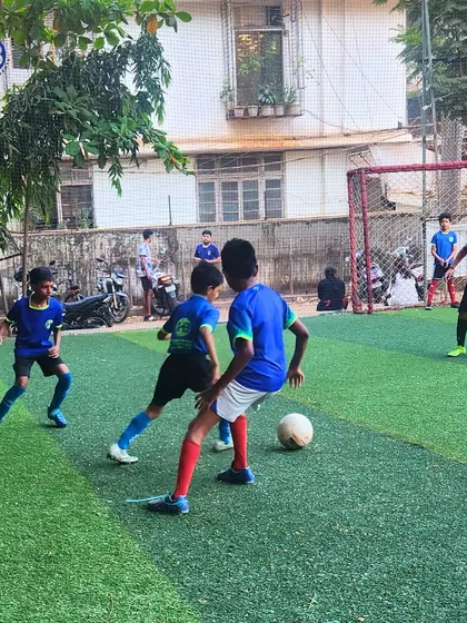 Two players face off during a football match on the turf. This action shot captures the competitive spirit and intensity of our training games.