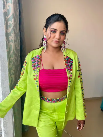 A confident and stylish look. The entire ensemble, from the outfit to the makeup, is a statement.