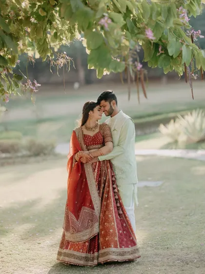 A romantic embrace under a flowering tree. The soft, natural light and beautiful surroundings create a perfect setting for a love story.