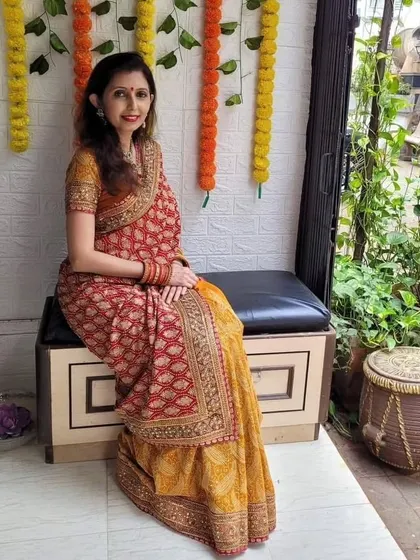 A seated pose in the "Infinity Drape," showing how the pleats and layers fall gracefully. This style works beautifully with sarees that have rich borders and patterns.