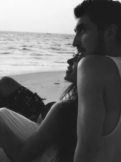 A quiet, contemplative moment from a beach photoshoot. This close-up captures the feeling of just being together, watching the waves, lost in a shared experience.