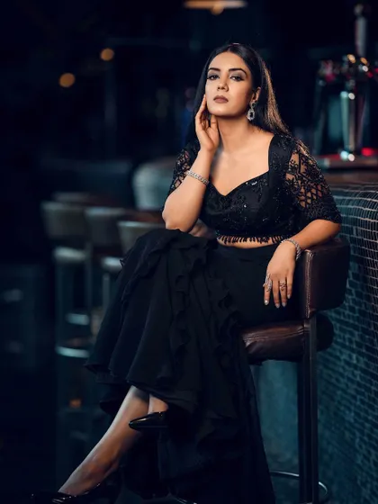 This pose, with the leg extended, showcases the mermaid cut of the skirt and the high-heeled shoes, giving a full view of the styling.