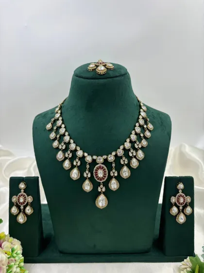A close-up of the earrings and tikka from our Moissanite Kundan set. This highlights the fine craftsmanship and the combination of red and white stones.