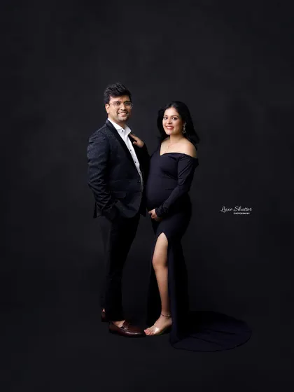 A classic and elegant couple's portrait. The simple black outfits and dark background create a sophisticated and timeless look.