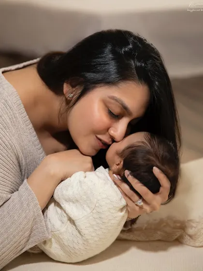 A mother's gentle kiss for her sleeping newborn. These are the quiet, love-filled moments that define the fourth trimester.