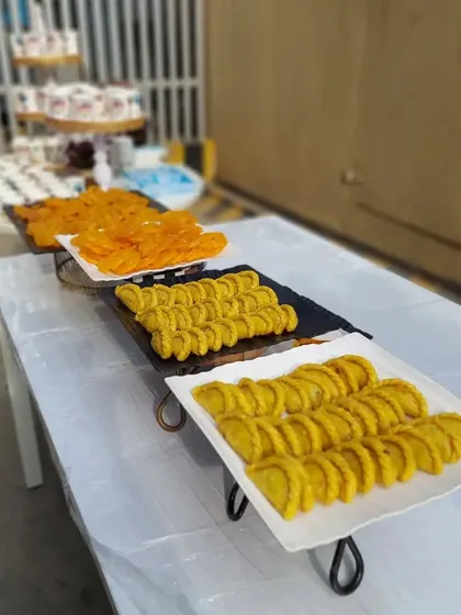 A dessert table featuring traditional Indian sweets for a corporate Holi party. This setup includes platters of jalebis and gujiyas, essential treats for a truly festive experience.