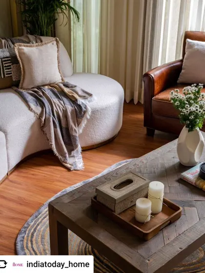 A press feature image from India Today Home, highlighting a cozy corner of a living room. The mix of a plush curved sofa and a classic leather armchair shows our signature blend of comfort and character.
