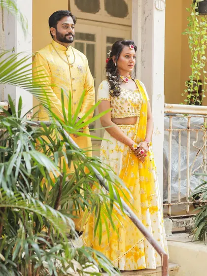 A more formal portrait of the couple in their matching yellow Haldi outfits, looking elegant and ready for the festivities.