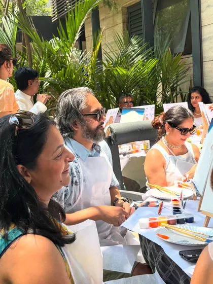 A sunny day is perfect for an outdoor paint party. This group of adults is enjoying the fresh air, good company, and a relaxing painting session.