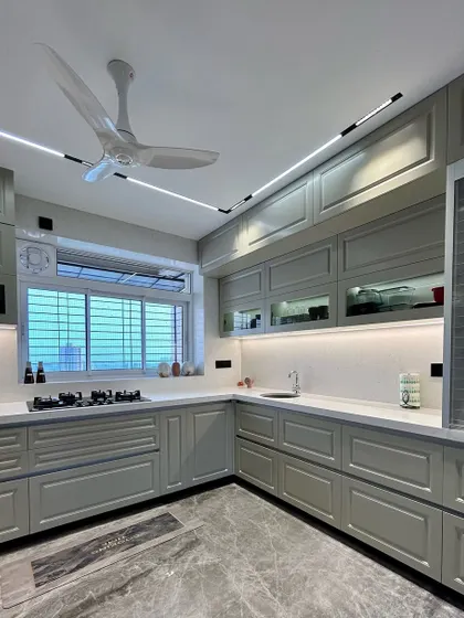 A classic vintage-inspired kitchen in a soft grey finish. The design includes shaker-style cabinets, under-cabinet lighting, and a marble-patterned floor for a timeless look.