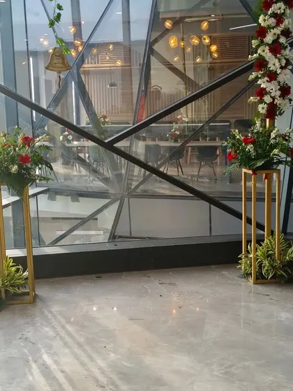 I used modern golden stands with red and white floral arrangements to decorate key points in the office. These stands add a touch of elegance to corners and entryways.