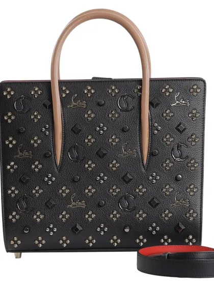 A front-on shot of a black Christian Louboutin tote, capturing the intricate stud and logo pattern against a clean white background.