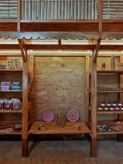 Inside, the versatile wooden columns double as display racks for local handicrafts. The design includes a mezzanine level to maximize space while maintaining an open feel.