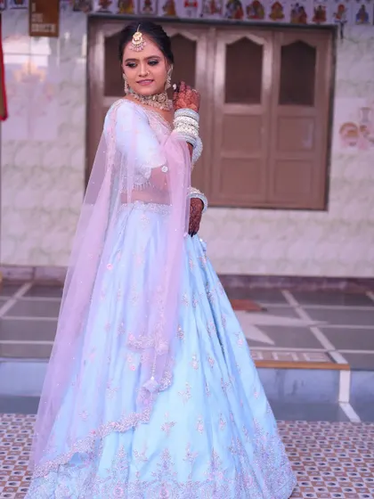 A full-length view of this pretty bride in her pastel blue lehenga, a popular choice for modern daytime weddings.
