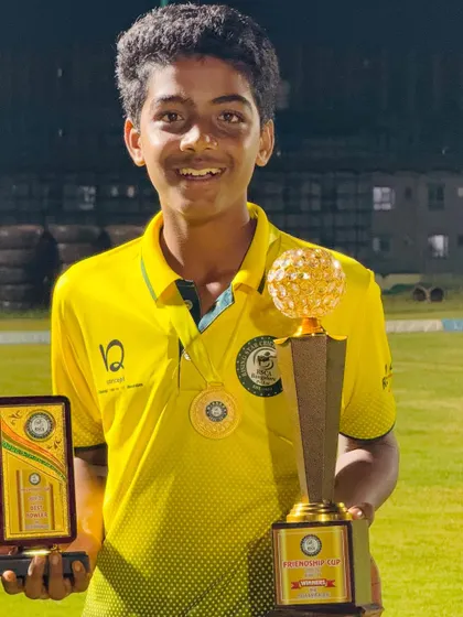 A player showcases both his individual award and the team's championship trophy.