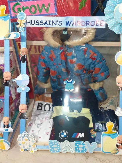 This hamper includes a warm winter jacket and other clothes for the baby boy.