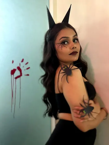 A full view of the Halloween costume, with devil horns and creepy spiders completing the spooky vibe.