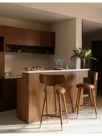 The bar area is bathed in natural light, highlighting the texture of the wood and the clean design of the custom furniture.