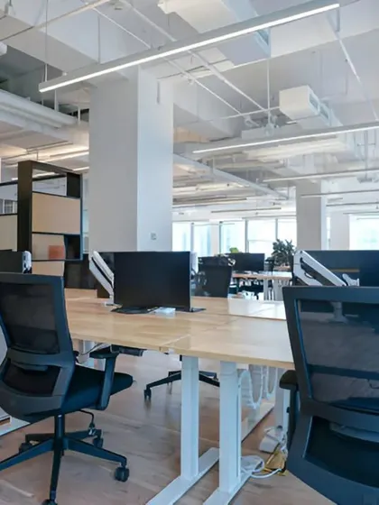 A perspective from behind the workstations, showing the clean lines and organized layout designed for a modern, collaborative workforce.