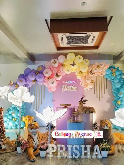 A wide shot of the impressive butterfly jungle setup, showing the full scale of the balloon arch and prop arrangement.