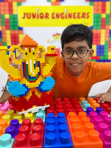 A smiling student poses with his large LEGO Ganesha, a highlight of our festive workshop series.