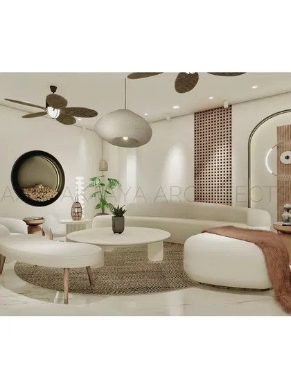 This living room design uses a soft, neutral palette and curved furniture to create a welcoming and comfortable space. A large, round fireplace niche and an evil-eye-inspired wall light add unique, sculptural elements to the serene setting.