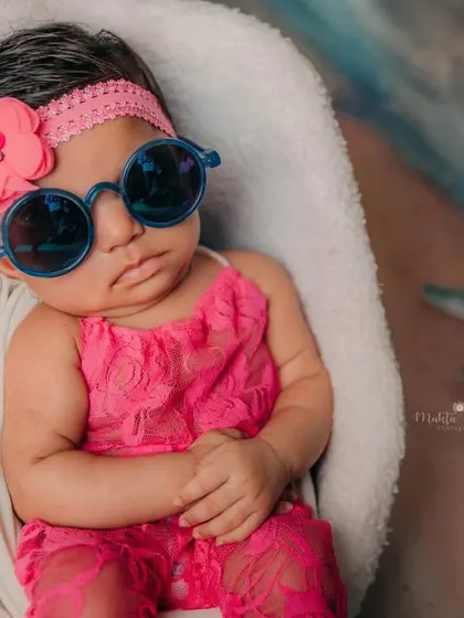 Even the tiniest clients have the biggest personalities. This little one is soaking up the studio beach vibes with her cool sunglasses and adorable pink outfit.