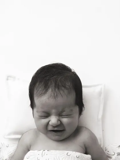 A real, expressive moment from a newborn. Not every photo is a perfect smile, and these authentic expressions are just as precious.