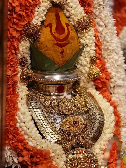A close-up of the decorated kalasha, which is the heart of the Varamahalakshmi pooja. I guide you on how to adorn it with a turmeric-smeared coconut, mango leaves, and sacred jewelry.