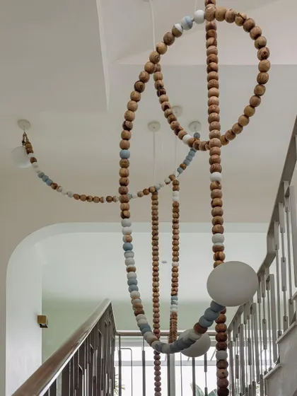 A close-up of the LUNA installation shows the texture of the wooden beads and the soft glow of the integrated lights. It's a piece that is as beautiful up close as it is from a distance.