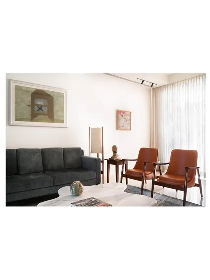 An afternoon view of the living space, where the custom marble coffee table catches the light. The surrounding seating, including the sofa and armchairs, was chosen to create a comfortable and elegant room for relaxing.