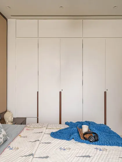 A view of the floor-to-ceiling white cupboards in the kids' room, which offer extensive storage. The clean design helps maintain a practical and organized space for play and rest.