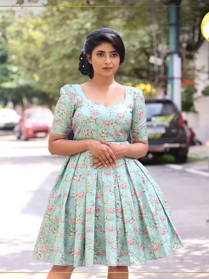 The full view of this sweet, vintage-inspired look. The makeup is kept fresh and pretty to complement the floral dress and classic hairstyle.