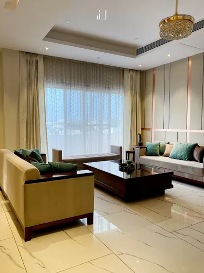 A closer look at the living area from our Ghibli trend project, showcasing the plush sofas and a large center table. The sheer curtains allow ample natural light while maintaining privacy.