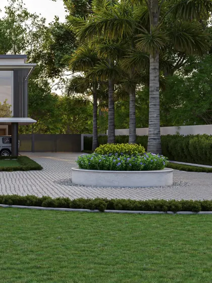 A circular planter bed in the driveway adds a soft, organic element to the otherwise linear and geometric design of the landscape and outhouse. This detail helps to guide circulation and adds a touch of curated nature.