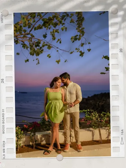 A beautifully framed shot of the couple against a stunning sunset sky over the sea in Mumbai.