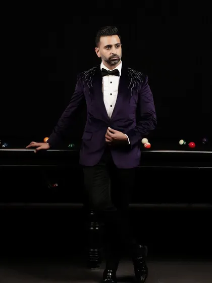 We crafted this deep purple velvet tuxedo for the modern gentleman who isn't afraid of color. The jacket features subtle black crystal embellishments on the shoulders, adding a touch of understated luxury.