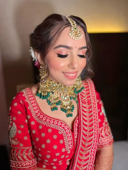 Akshita's vision for her bridal look came to life perfectly. A soft pink eyeshadow and glowing skin to complement her traditional red lehenga.