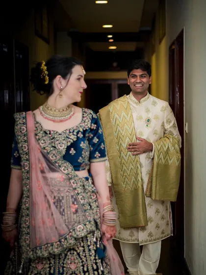 A candid moment between a cross-cultural couple, sharing a look of love and happiness.
