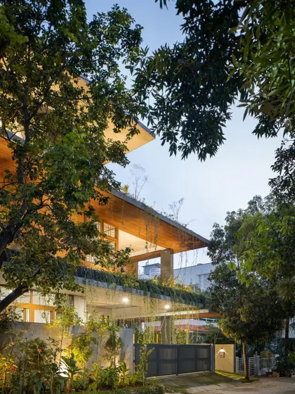 The house illuminated at twilight, creating a warm and welcoming presence on the street.