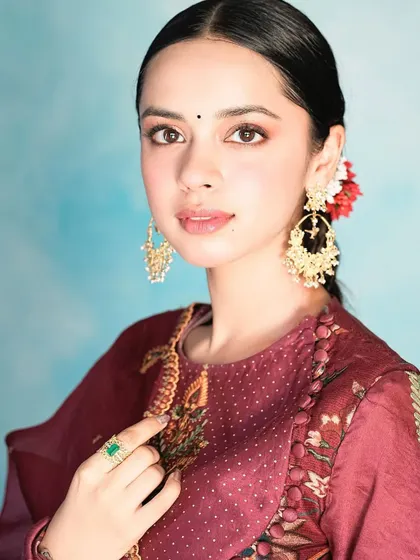 Nitanshi Goel wearing my large gold jhumka earrings and an emerald ring. The combination of traditional jhumkas with a contemporary ring creates a balanced and beautiful look.