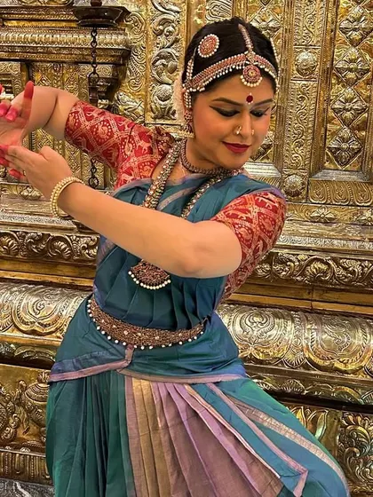 Another expressive shot from a temple performance. The intricate gold background of the temple sanctum beautifully complements the traditional blue and purple dance saree, creating a visually rich and devotional atmosphere.