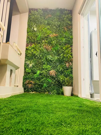 This installation shows how a vertical garden can make a narrow utility balcony feel like a deliberate design feature. The green wall adds life and color, complemented by a clean artificial turf floor.