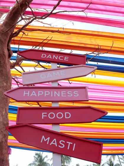 Custom signage points the way to 'Dance, Game, Happiness, Food, Masti', setting a fun and festive tone for the celebration.