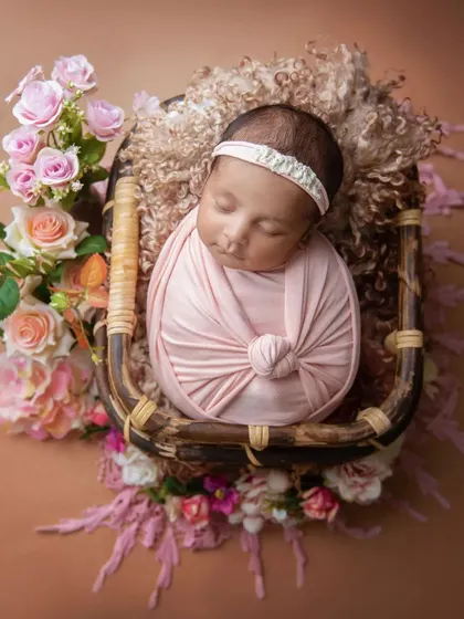 This overhead shot in a basket shows how I use layers of soft fabrics and flowers to create a beautiful, nest-like setting for your baby.