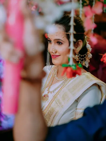 A beautiful, soft focus shot of the bride, framed by flowers, as she awaits the start of the ceremony.