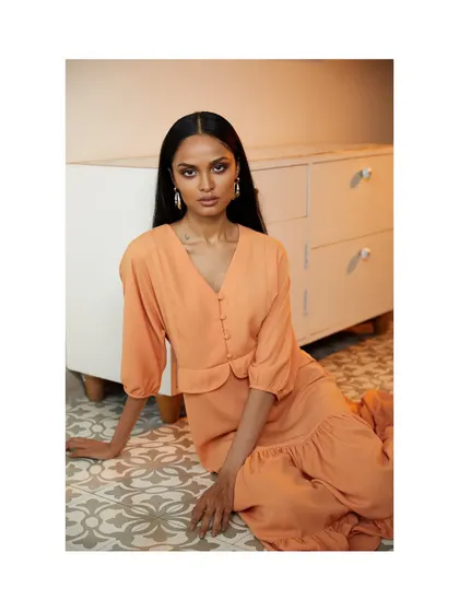 A soft and beautiful portrait for a clothing brand. The peach dress and the patterned floor create a warm and inviting atmosphere.