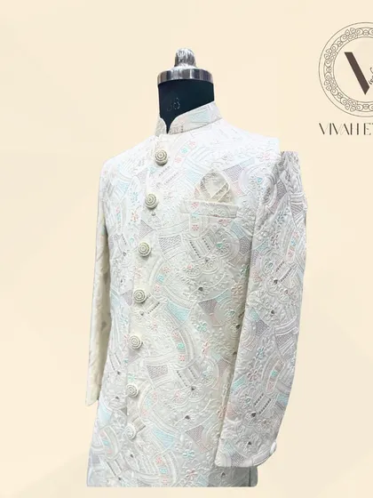 A detailed side-angle shot of the ivory sherwani, focusing on the sleeve and button placket. This view highlights the density and craftsmanship of the pastel-colored embroidery against the ivory base fabric.