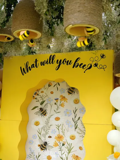 A full shot of the beautiful photo backdrop, showing how the hanging beehives, floral arrangements, and balloon clusters frame the central display for a picture-perfect moment.