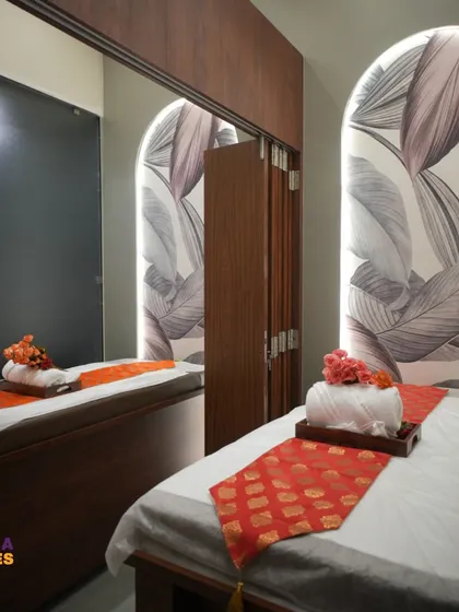A mirror wall in the treatment area creates a sense of spaciousness. It reflects the calming design elements, like the backlit arch and warm wood tones, making the room feel larger and more immersive.